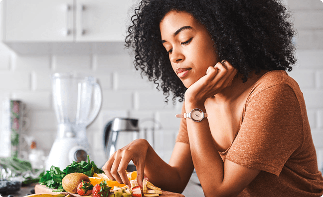 Woman eating fruit in her kitchen
